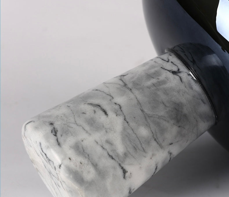 Marble-textured object with a black rim on a light gray background