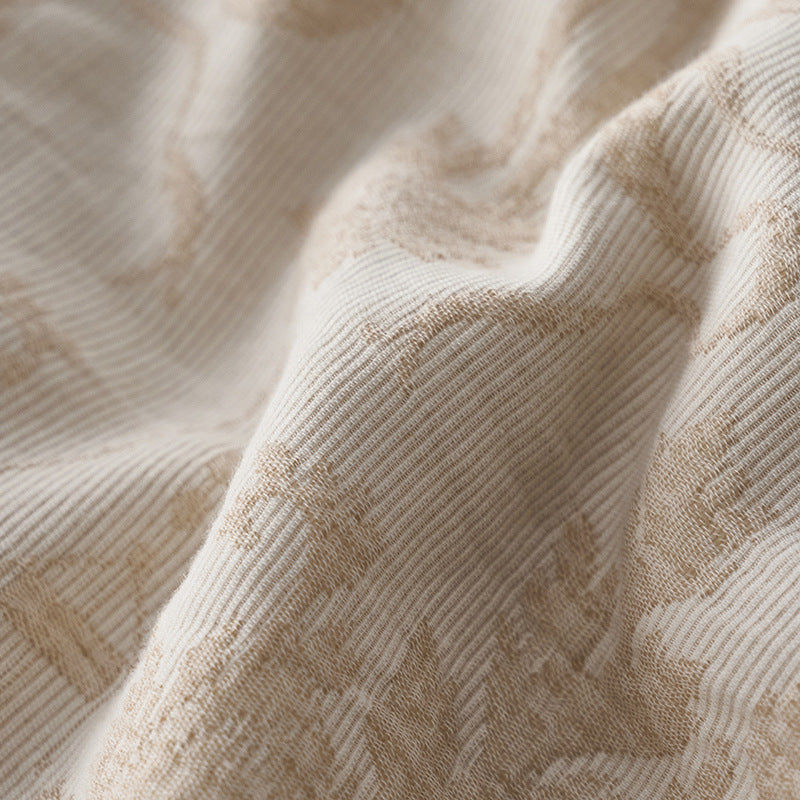 Close-up of woven damask jacquard cotton fabric showing subtle texture and tonal pattern.