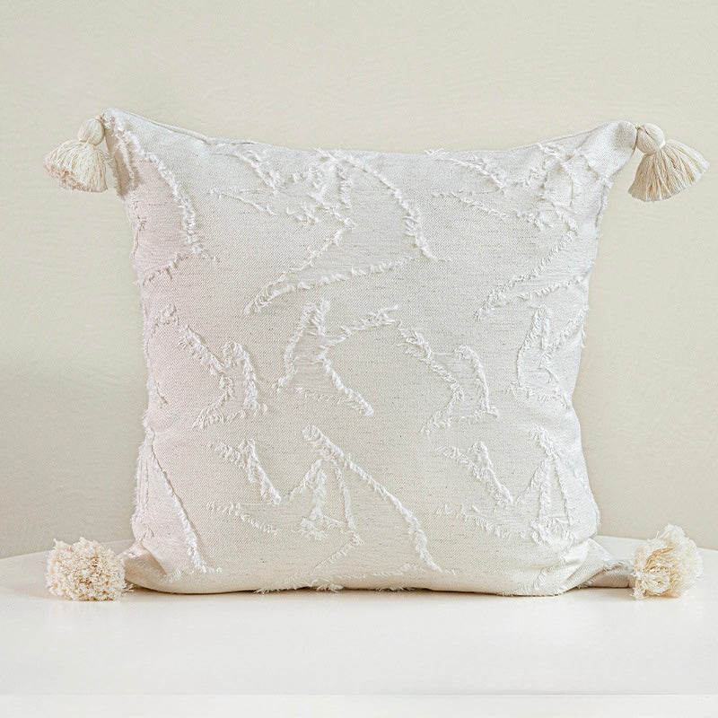 Square 45x45 cm white cotton blend cushion with hand-finished corner tassels and raised artisanal motifs.