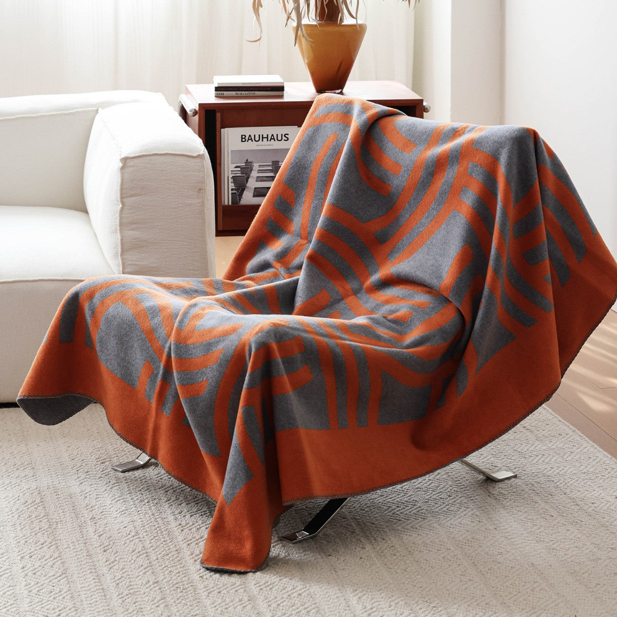 Atelier Graphite geometric woven throw blanket on a minimalist armchair.