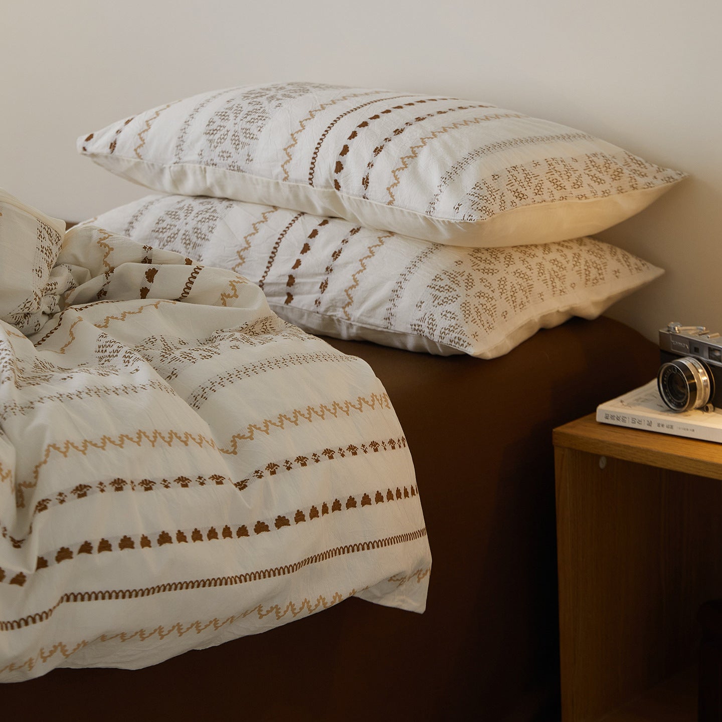 Pair of jacquard pillowcases styled against a cocoa-brown brushed cotton backdrop for a layered aesthetic.