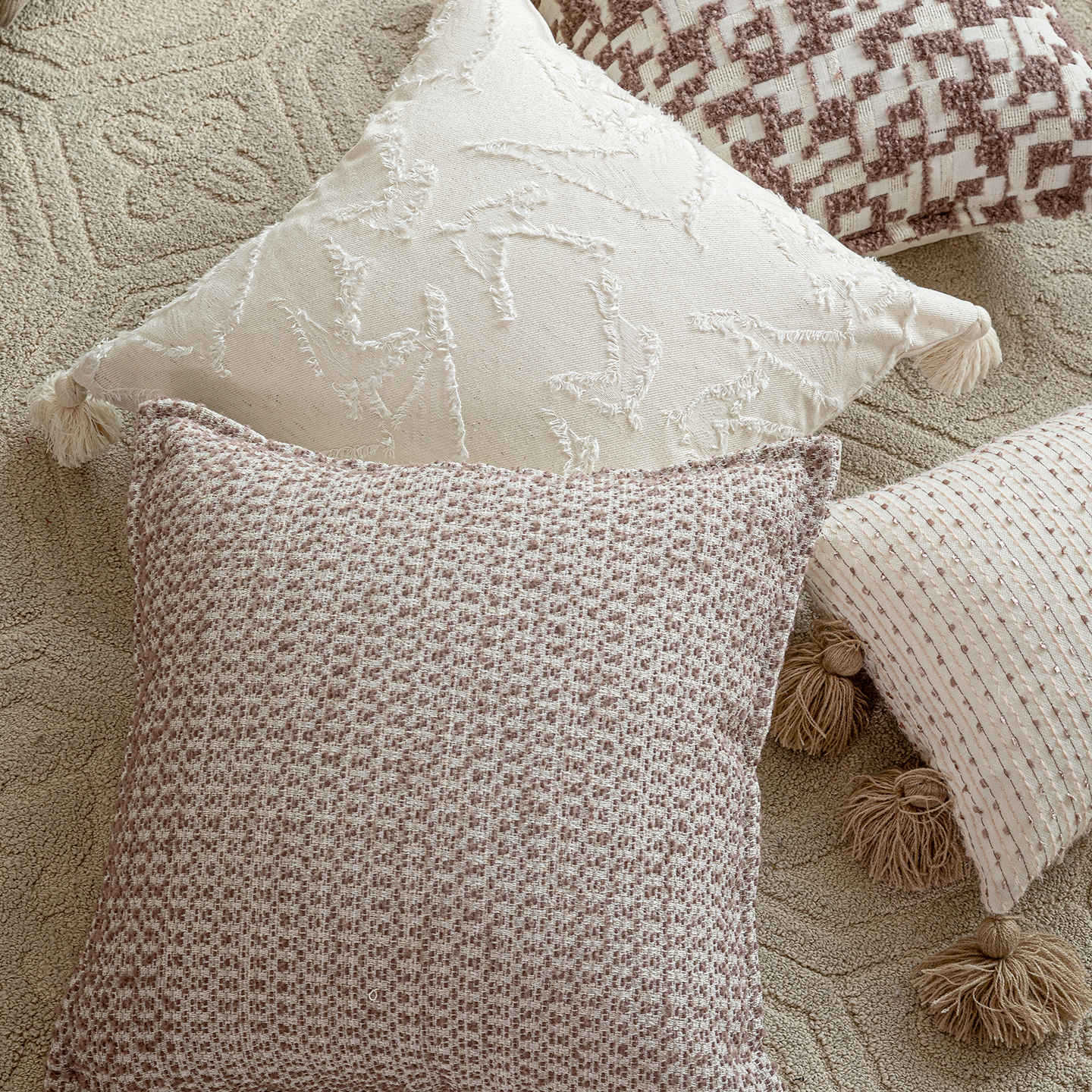 Macro shot of a hand-finished corner tassel on a woven cotton-blend decorative pillow.