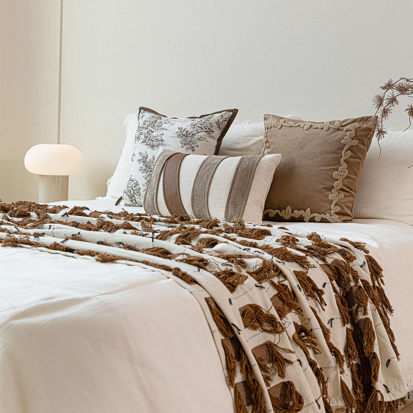 Layered bed styling featuring Heritage Atelier cushions and fringe bed runner