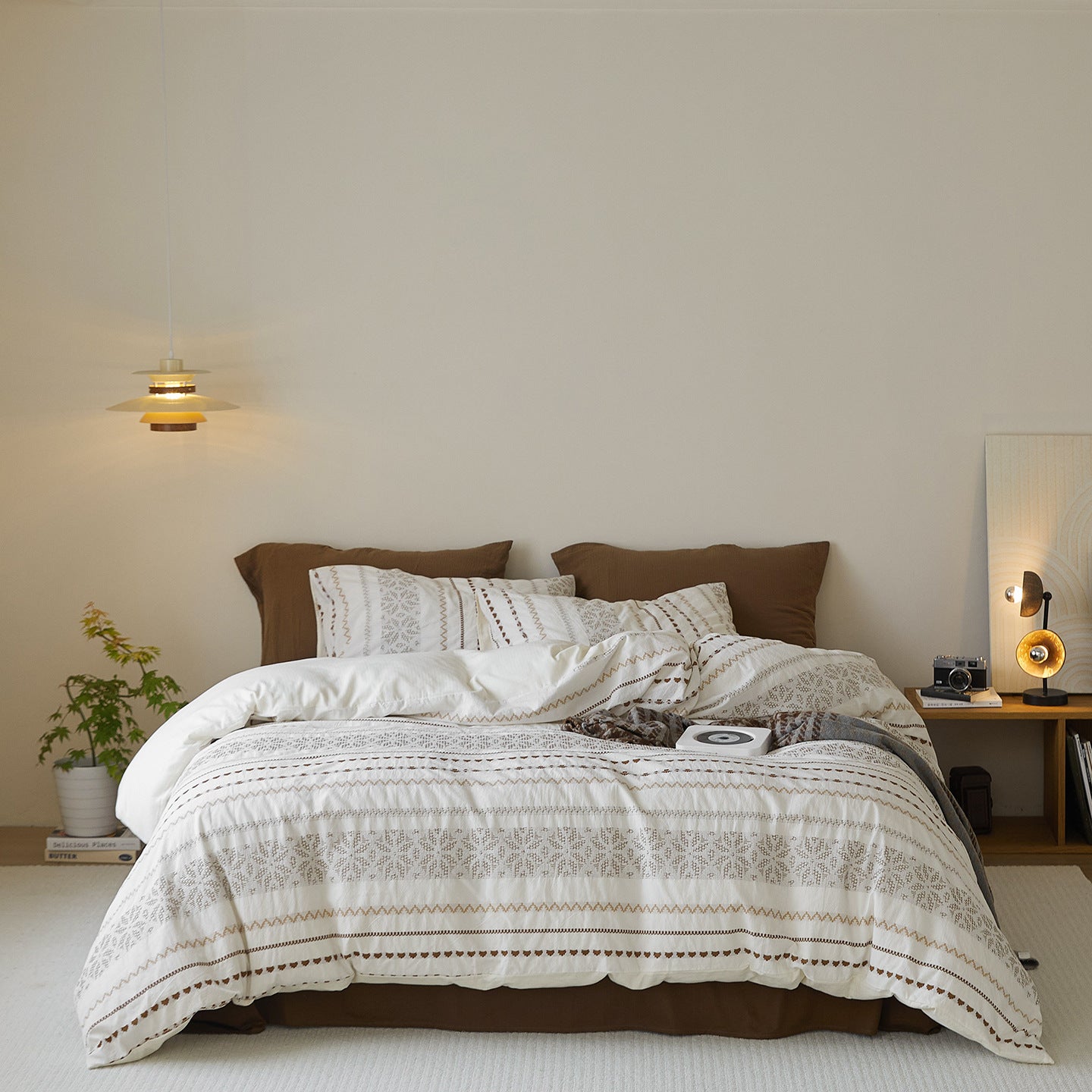 Full view of Atelier Damask Jacquard bedding set in écru and cocoa cotton, featuring woven geometric borders and floral motifs in a minimalist bedroom.