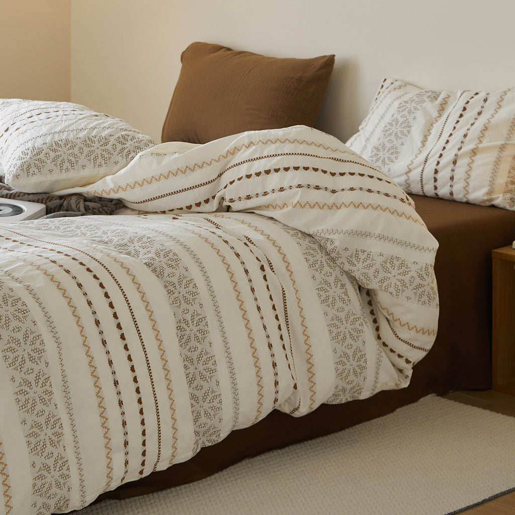 Angled view of styled nomadic bedding with textured jacquard patterns, ideal for contemporary earthy bedroom decor.
