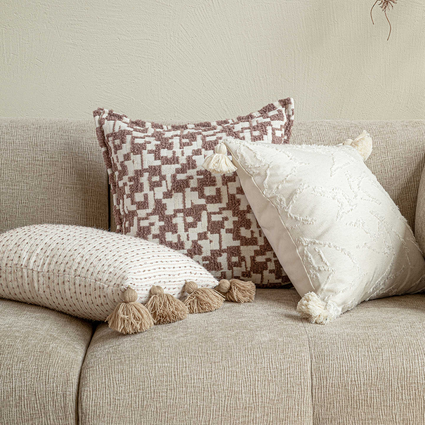 A styled pair featuring the 30x50 linear tassel lumbar pillow and the white 45x45 tufted square, showcasing premium down-filling and hand-finished details.