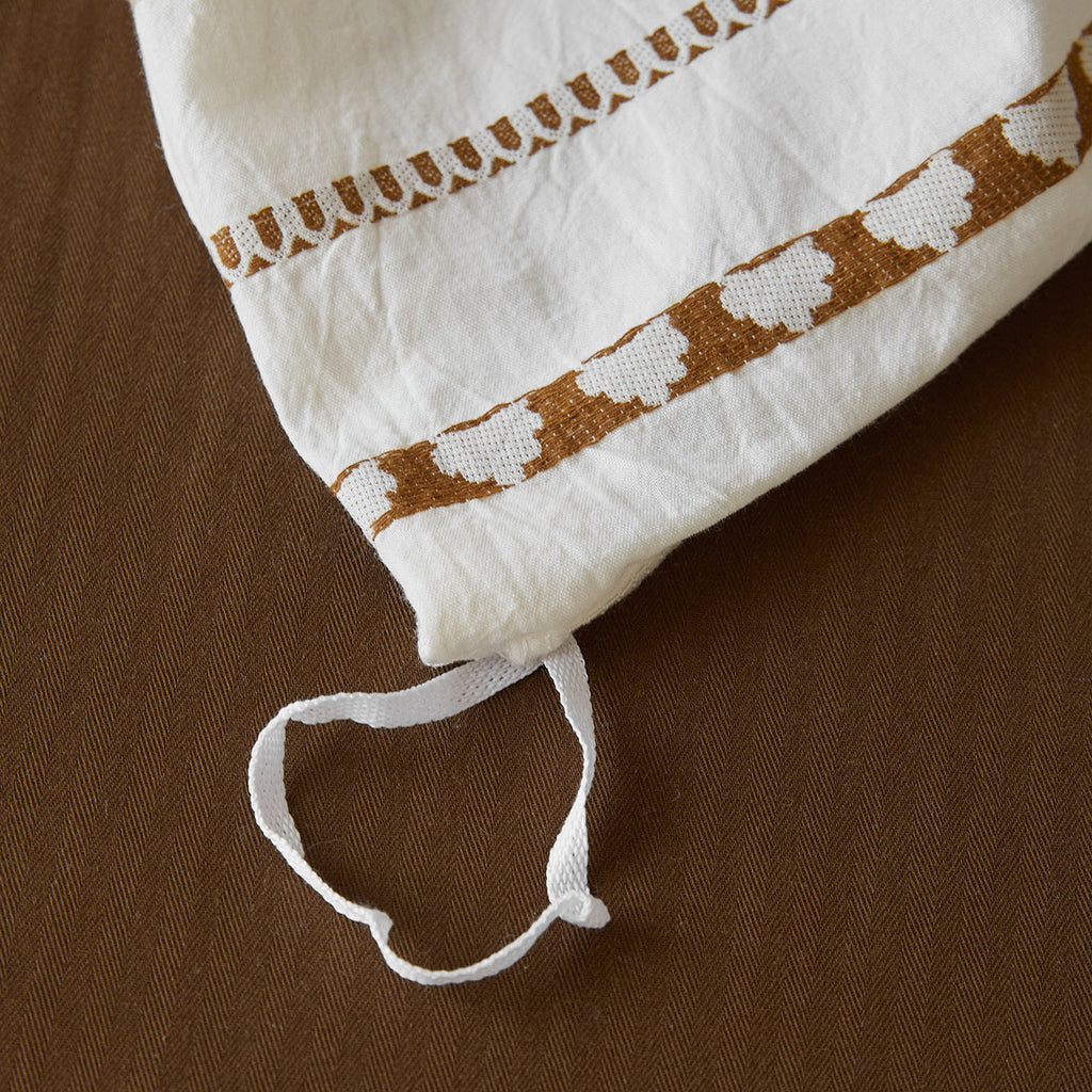 Macro detail of the jacquard weave pattern showing the heart and chevron borders woven directly into the 100% cotton fabric.